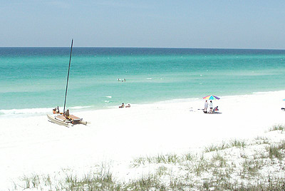 The Emerald Coast Beach with catamaran and beach umbrella